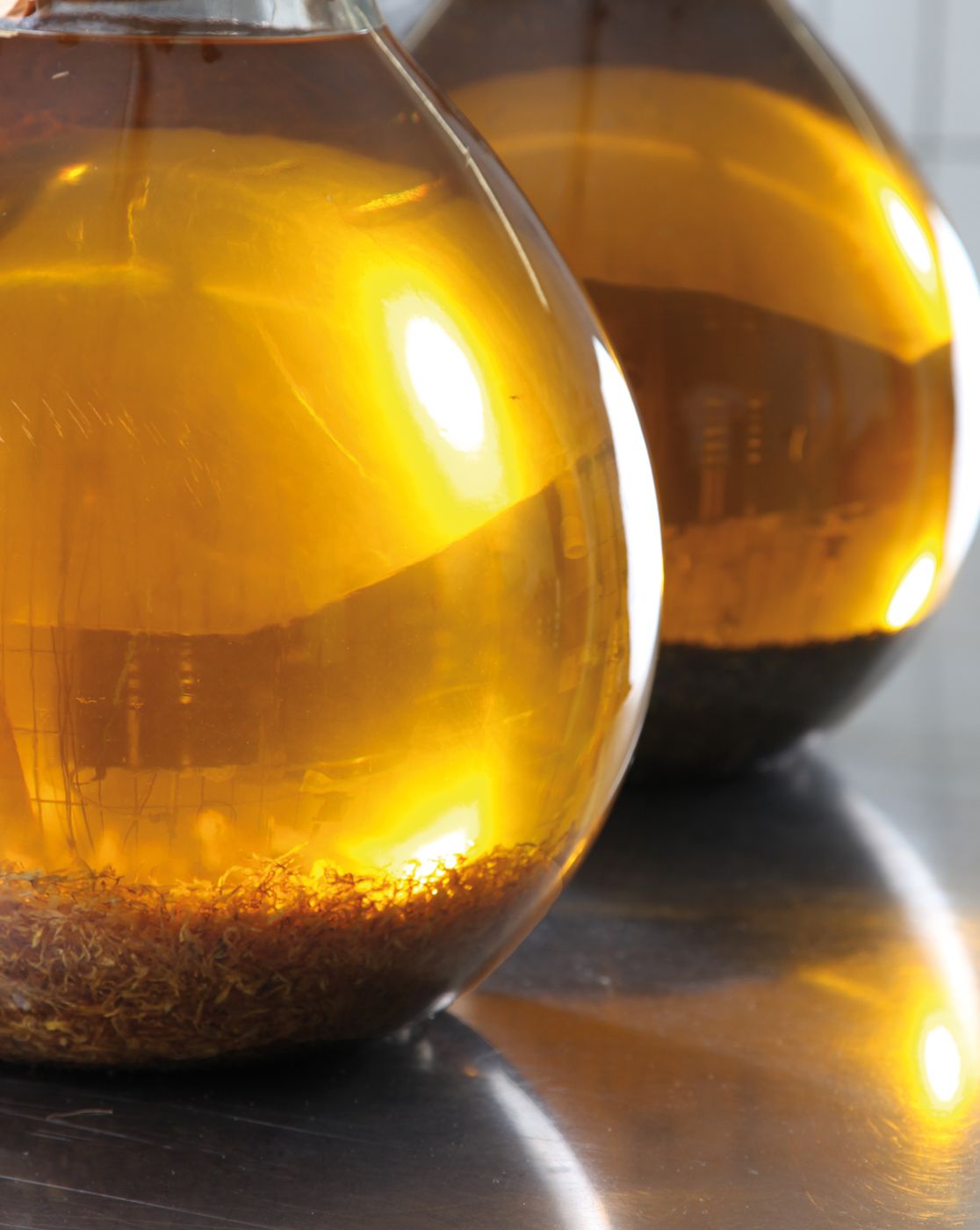 Zwei Glaskolben mit goldenem Ringelblumen-Ölmazerat